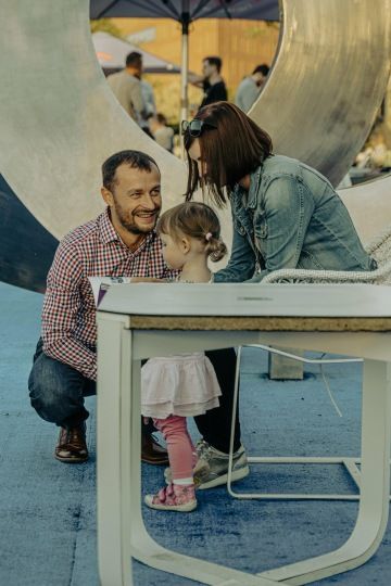 Rodinná scéna venku s dětmi, symbol rodinné pohody a radosti.