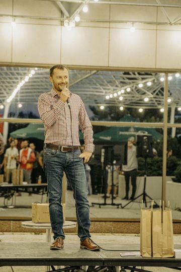 Člověk na pódiu během vystoupení, oslava týmového ducha.